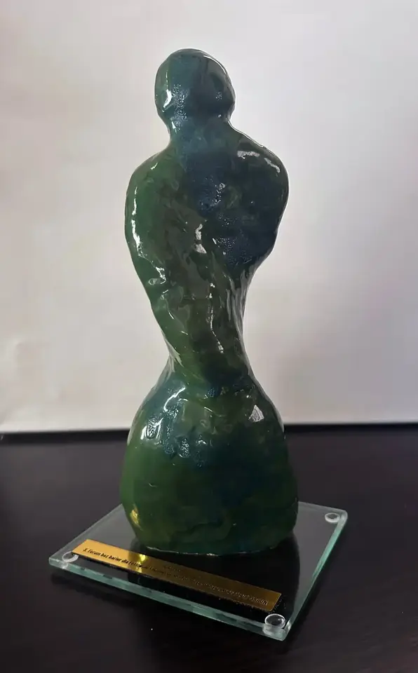 Zielono-granatowa antropomorficzna statuetka o skręconej osi i odchylonej głowie.